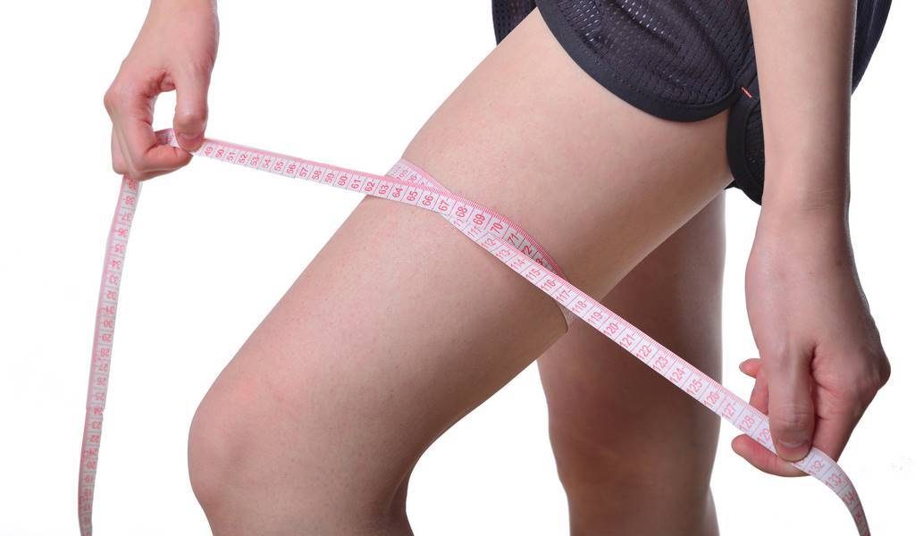 perfect womans legs measure by metre-stick over white
